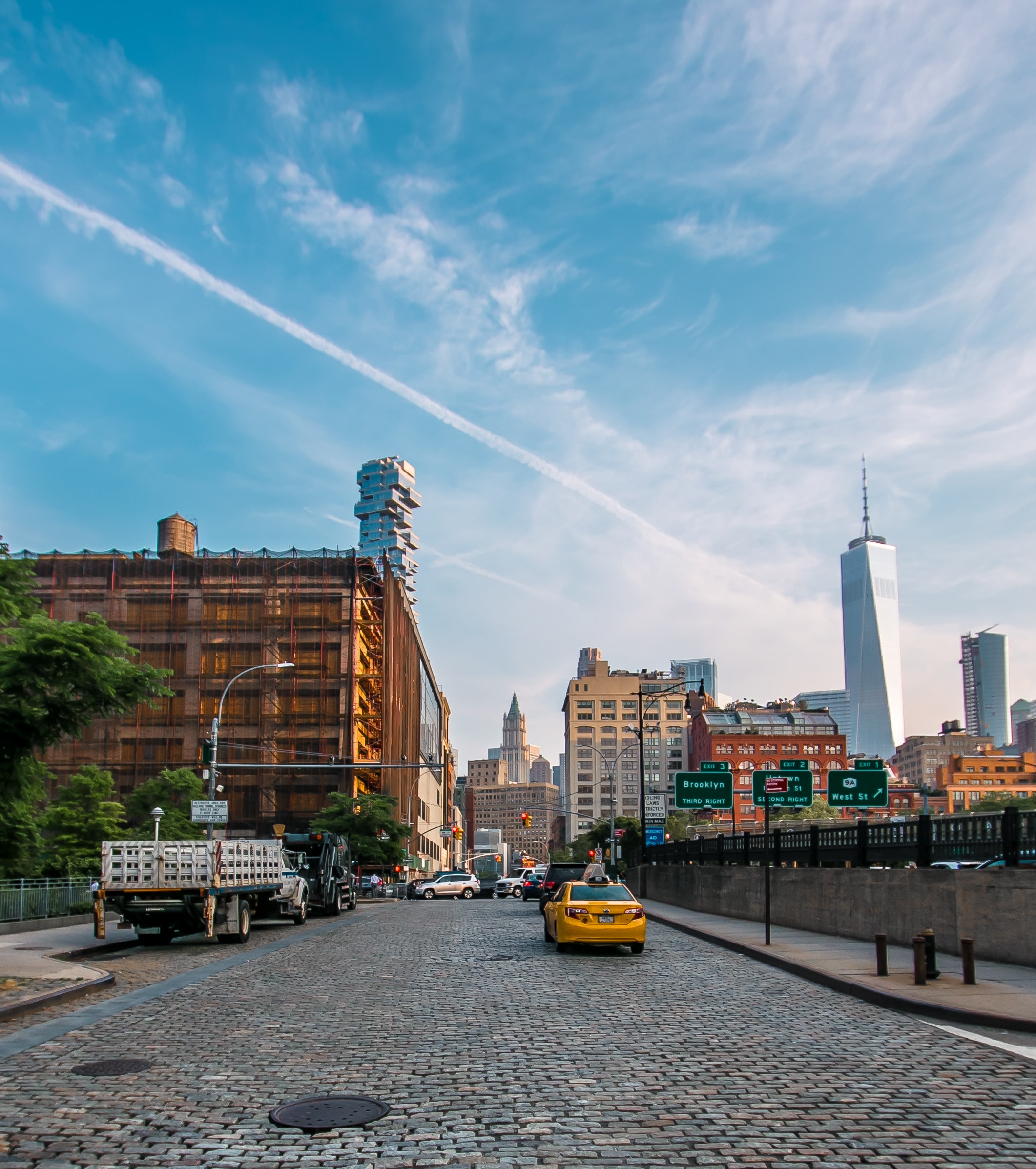 Lower Manhattan street with a yellow taxi and One World Trade Center